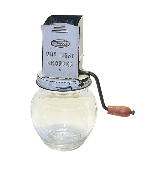 An Androck Nut Chopper from the 1940's with a metal chopping mechanism attached to a clear glass jar.