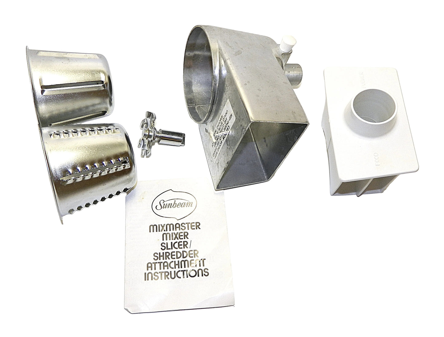 Metallic kitchen attachments for a mixer on a white background with a box of instructions.