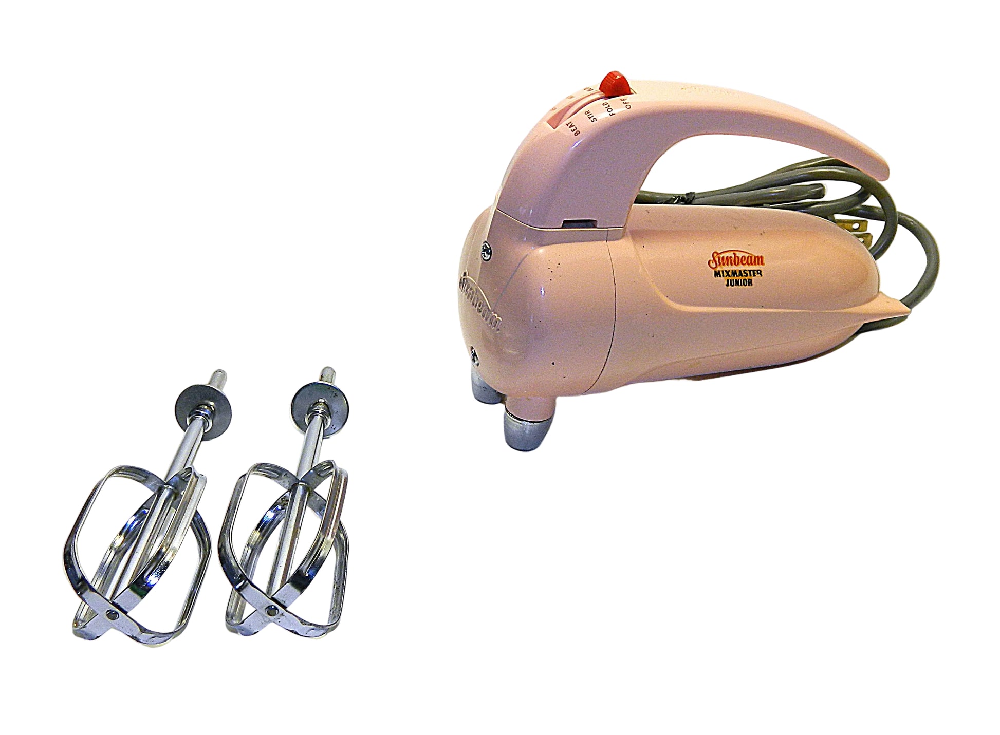 Vintage pink hand mixer with attachments on a white background
