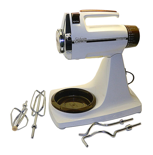 Vintage Sunbeam stand mixer with attachments on a white background