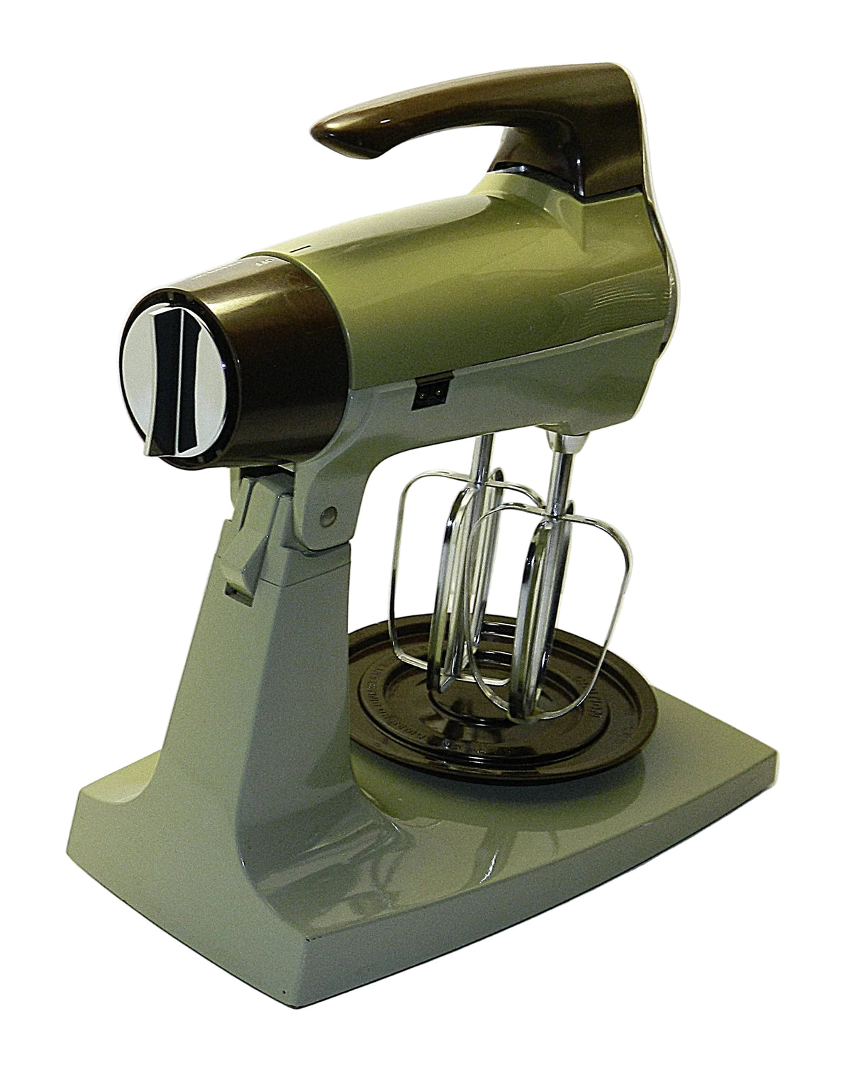 A vintage-style stand mixer with a glossy olive green body and dark brown accents, featuring two metal beaters and a round mixing plate, photographed against a plain white background.